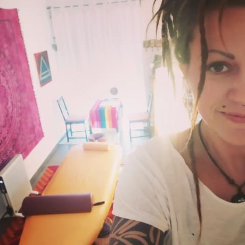 Bine Fetz lächelt neben einer Massageliege in ihrer Praxis